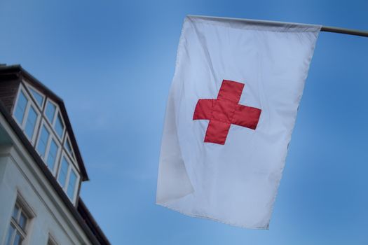 Early evening sky in the background of a Red Cross flag.