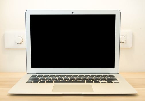 Perfectly detailed modern laptop computer placed on a wooden table.
