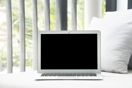 High-key image of Laptop on a chair and daybed.
