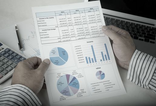 businessman analyzing data report on work desk.Vintage Style.