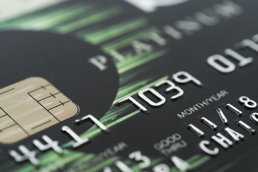 Close up credit card of detailed glossy green. Selective focus.