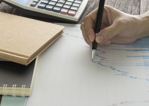 Work table with graph pad and a pen with a calculator.business concept.