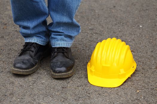 worker standing next to a yellow helmet