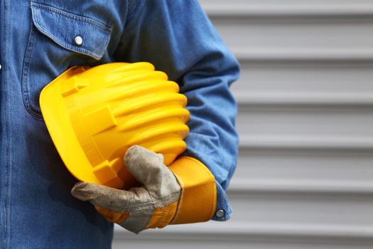 Man holding yellow helmet close up, shallow dof