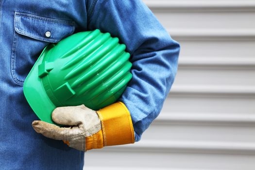 Man holding green helmet close up, shallow dof