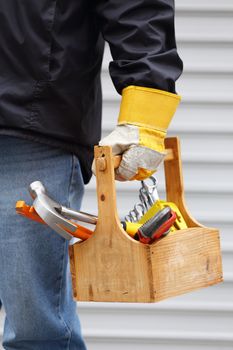 a worker holding a wooden toolbox close up