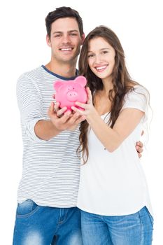 Couple holding piggy bank on white background