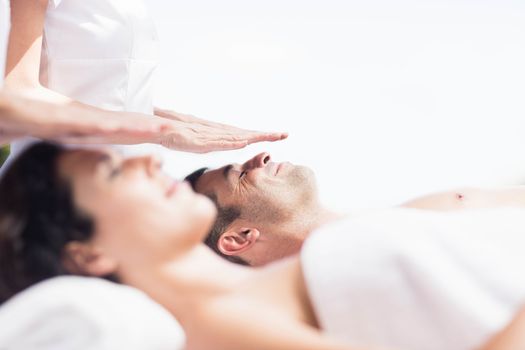 Couple receiving a head massage from masseur in a spa