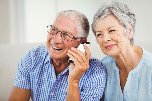 Senior couple smiling while talking on mobile phone