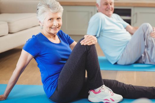 Senior couple performing yoga exercise at home