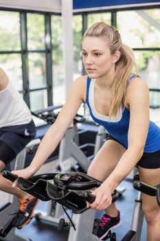 Fit group of people using exercise bike together in crossfit