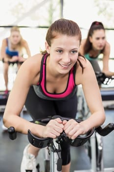 Fit group of people using exercise bike together in crossfit