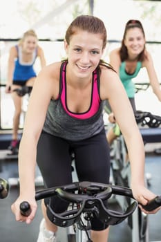Fit group of people using exercise bike together in crossfit
