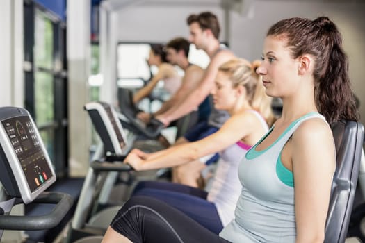 Fit people doing exercise bike at gym