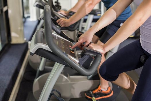 Fit people doing exercise bike at gym