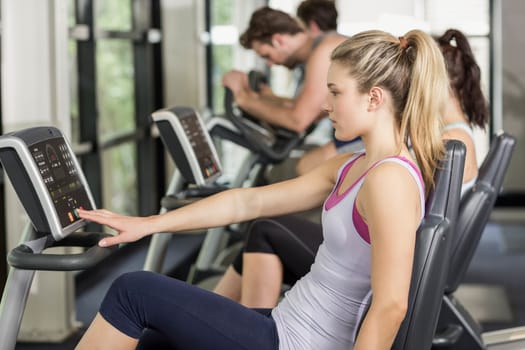 Fit people doing exercise bike at gym