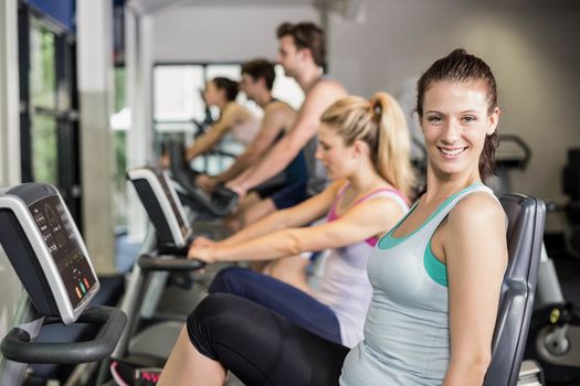 Fit people doing exercise bike at gym