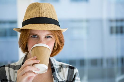 Fashion hipster having a coffee in a disposable cup