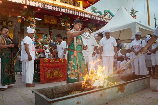 view of monk pouring water on fire during vegetarian festival in Thailand