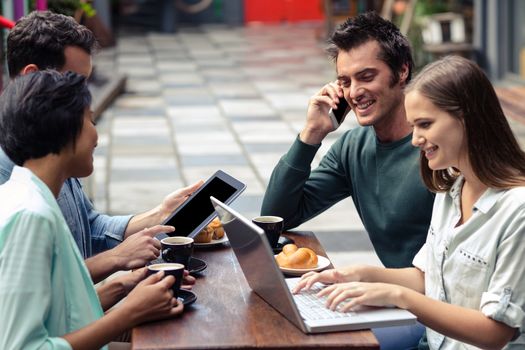 Friends sitting at the bar using technology 