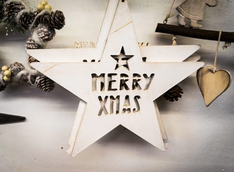 Background formed by white wooden stars with the words "merry xmas" carved.