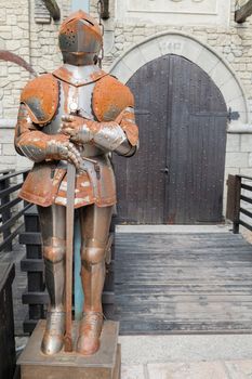 Medieval armor in front of the entrance to a castle.