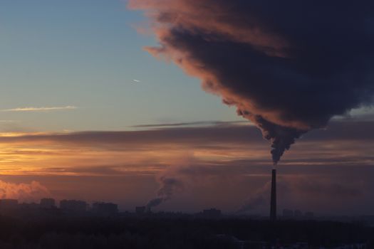 Tube with orange smoke on winter sunset