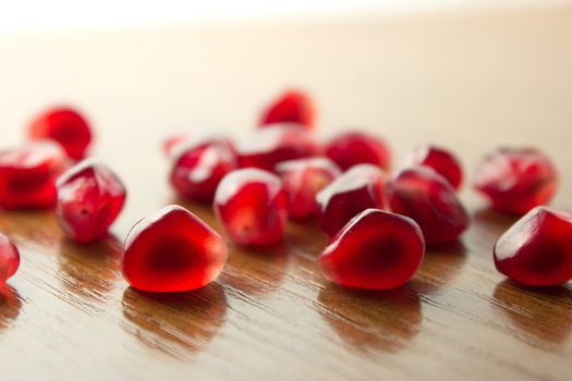 ripe, red garnets' seeds on wooden table