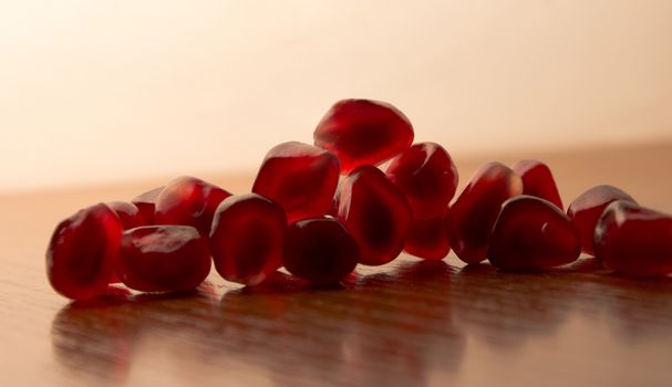 ripe, red garnets' seeds on wooden table