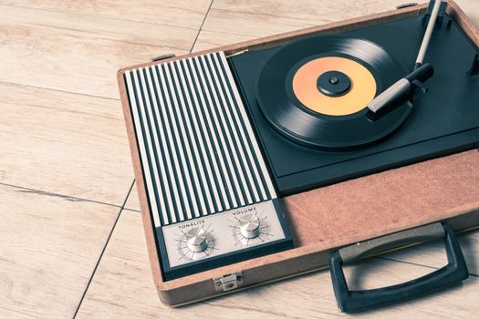 Gramophone with a vinyl record on wooden table,photo desaturate and split toning for old style.