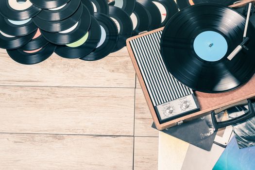 Gramophone with a vinyl records on wooden table, top view and copy space,photo desaturate and split toning for old style.