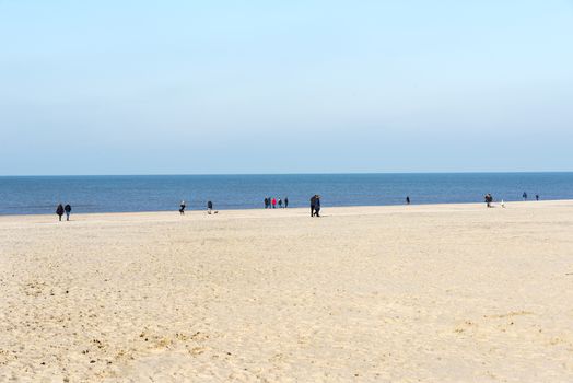 HOEK VAN HOLLAND,NETHERLANDS - FEBRUARI 17: Unidentified people walking on the beach near the sea on Februari 17 2016 in Hoek van Holland, this beach is the beach with the view on inccoming ships to Rotterdam harbour.