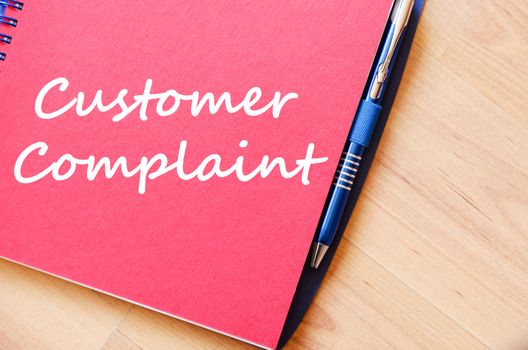 Customer complaint text concept write on notebook with pen