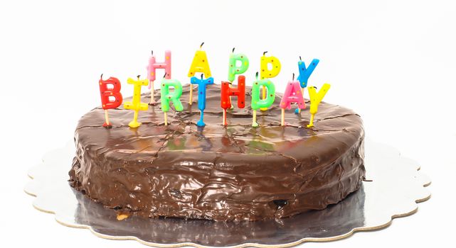 Chocolate happy birthday cake on silver tray towards white