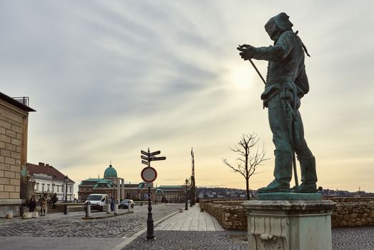 BUDAPEST, HUNGARY - FEBRUARY 02: Statue of a Hussar inspecting the edge of his sword, with Buda Castle in the background. February 02, 2016 in Budapest.