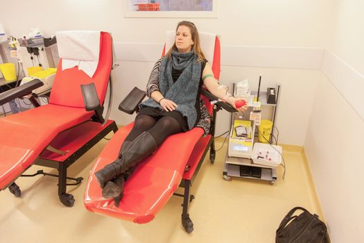 Donor in an armchair donates blood at hemotransfusion station