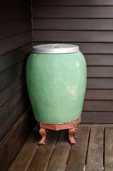 Thai jar,Glazed pottery for water storage on Thai wooden house.