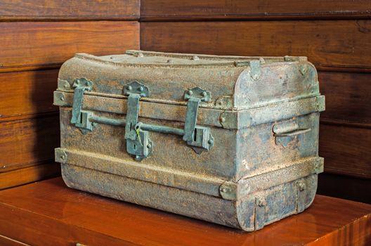 Ancient metal chest on wood table.