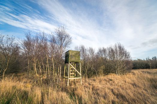 Autumn nature with a hunting tower on a field