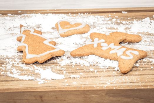Xmas cookies in flour on a wooden board