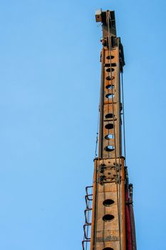 Tall industrial piling machine isolated on blue background