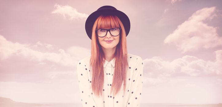 Smiling hipster woman holding book belt  against beach with blue sky