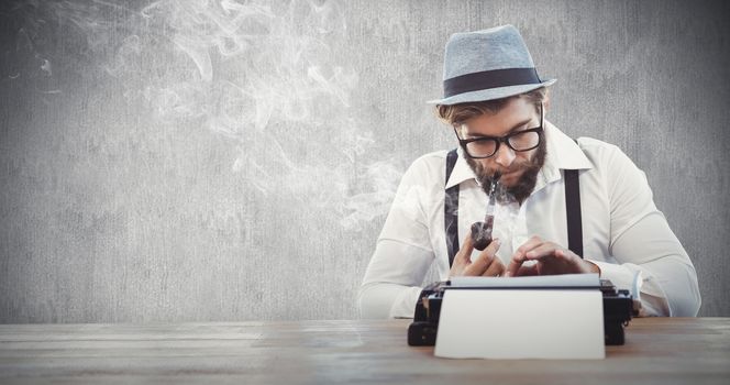 Hipster smoking pipe while working at desk against white and grey background