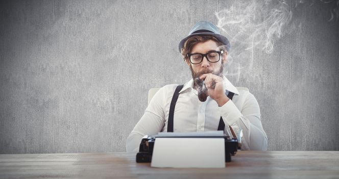 Hipster smoking pipe while sitting looking at typewriter against white and grey background