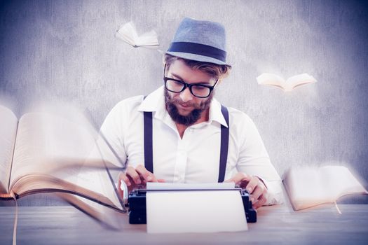 Hipster wearing eye glasses and hat working on typewriter against white and grey background