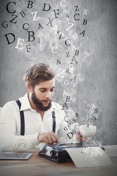 Hipster holding coffee working on typewriter against white and grey background