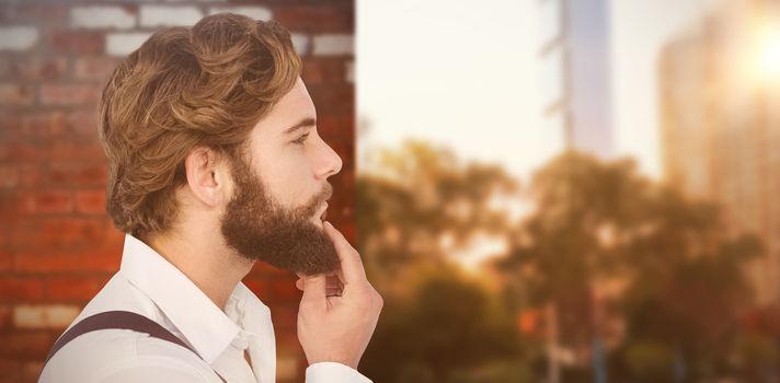 Profile view of hipster touching beard against wall of a house