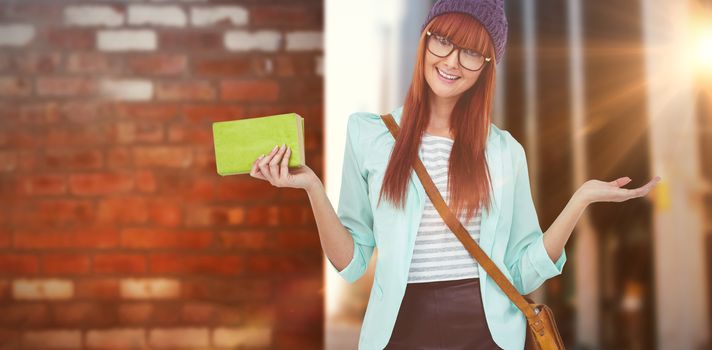 Smiling hipster woman with bag and book against wall of a house