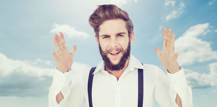 Portrait of happy hipster gesturing against blue sky