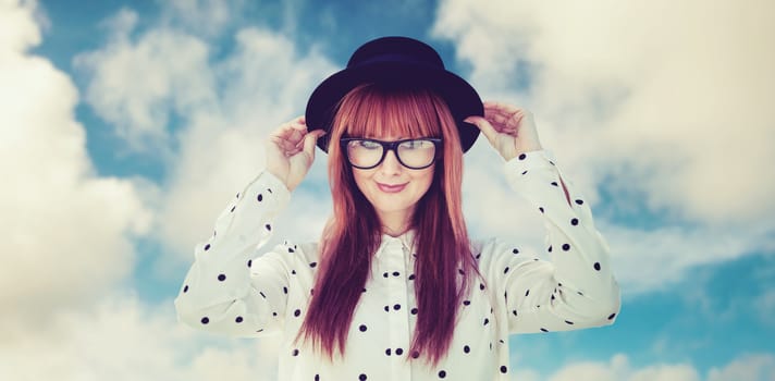 Attractive smiling hipster woman with hat  against road leading out to the horizon